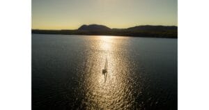 Vue aérienne du Lac Memphrémagog au coucher du soleil avec voilier et paysages de l’Estrie