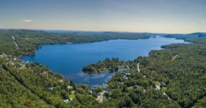 Vue aérienne du Lac Brompton en Estrie montrant le lac, les propriétés riveraines et le paysage naturel environnant