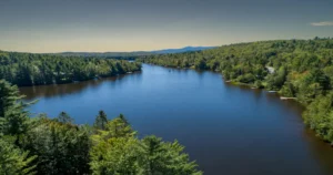 Vue aérienne du lac Desmarais en Estrie entouré de forêt et de propriétés près de l’eau