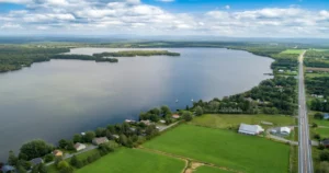 Vue aérienne du Lac Drolet en Estrie montrant le lac, les propriétés riveraines, les terres agricoles et le paysage naturel environnant