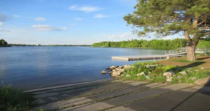 Vue du lac Louise en Estrie avec quai, accès à l'eau et propriétés riveraines entourées de nature.